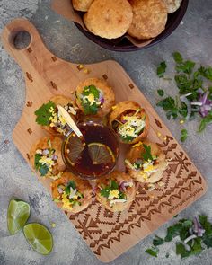 an overhead view of some food on a cutting board with dipping sauce in the middle