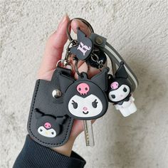 a person holding two keychains in their hand and one has a cat face on it