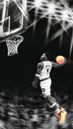 a basketball player jumping up into the air to dunk a ball in front of him