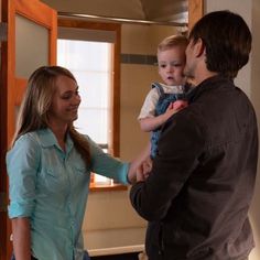 a man and woman holding a small child