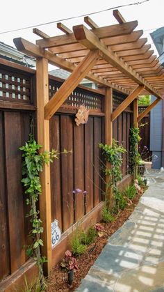 a wooden pergoline with plants growing on it