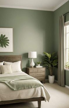 a bedroom painted in green and white with a bed, nightstands, window, and potted plant