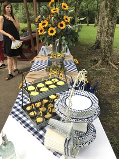 a table with sunflowers and cupcakes on it