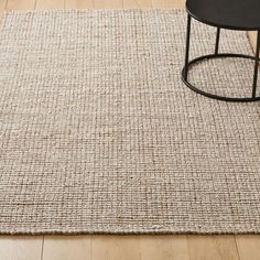 an area rug on the floor with a black table and chair in front of it