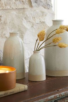 three vases and a candle on a table