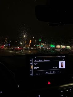 the dashboard of a car at night with fireworks in the air and buildings behind it