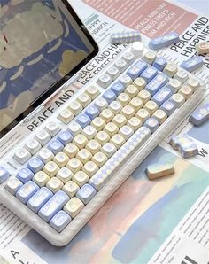 a computer keyboard sitting on top of a newspaper next to a tabletop with an image of a man in the background