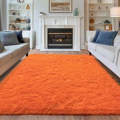 an orange rug is in the middle of a living room with two couches and a fireplace