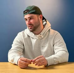 a man sitting at a table wearing a hat