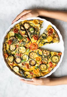 a person holding a plate with a pizza on it and one slice missing from the pie