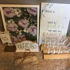 three wooden signs with flowers on them sitting next to each other in front of a wall