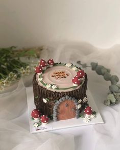 there is a cake that has mushrooms on it and flowers in the background with white fabric