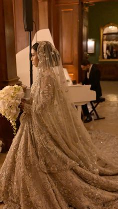 a woman in a wedding dress standing next to a piano