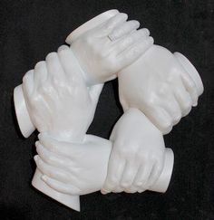 two white hands holding each other on a black surface