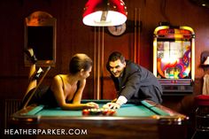 a man and woman playing pool in a casino