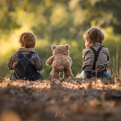 two children sitting on the ground with teddy bears