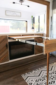 the inside of a camper with wood cabinets and an area rug on the floor