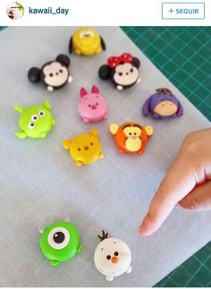 someone is pointing at some toy animals on a sheet of paper that they are made out of