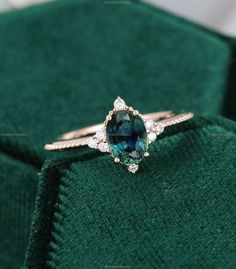 a blue and white diamond ring sitting on top of a green cloth