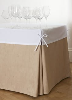 a table topped with lots of wine glasses on top of a hard wood floor covered in burlap