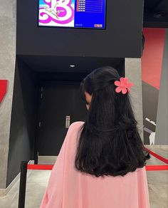 a woman with long black hair standing in front of a tv