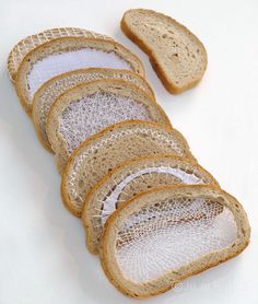 several slices of bread with white net on them sitting next to each other in front of a white background