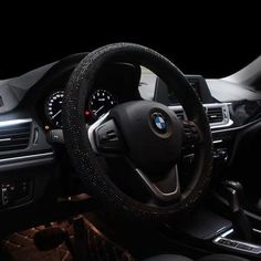 the interior of a car with steering wheel cover and dashboard gauges in black leather