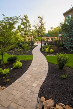 a brick walkway in the middle of a garden