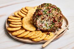 a plate with crackers and a cheese ball on it