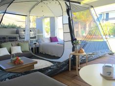 a living room filled with lots of furniture and a tent on top of a wooden floor