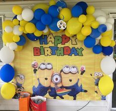 a birthday backdrop with balloons and minion characters