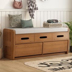 a wooden bench with two drawers underneath a coat rack and hanging hooks on the wall