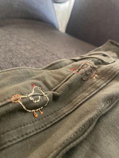 a pair of jeans with embroidered birds on them