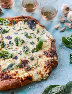 a pizza sitting on top of a blue table covered in cheese and veggies