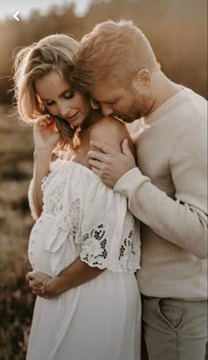 a man and woman embracing each other in an open field