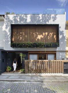 a person standing in front of a building with wooden slats on the outside wall