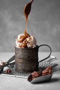 a scoop of caramel ice cream being poured into a cup