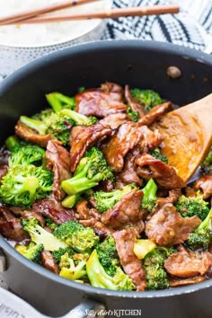 a pan filled with meat and broccoli on top of a table