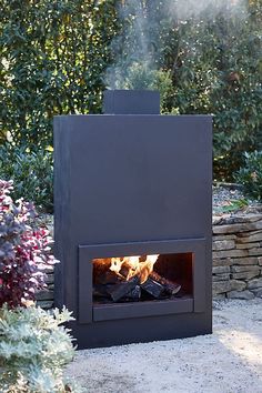 an outdoor fireplace in the middle of a garden