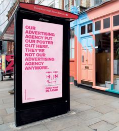 an advertisement on the side of a building in front of other buildings and people walking by