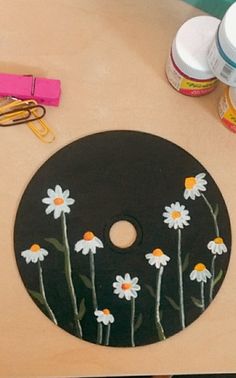 there is a black and white flower painted on the side of a table with scissors