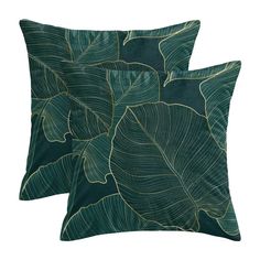 two pillows with green leaves on them, one has a black background and the other has gold