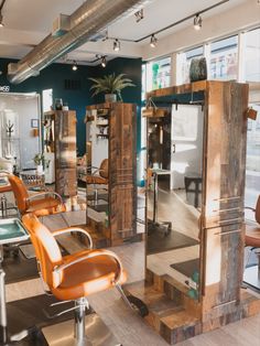 the inside of a hair salon with chairs and mirrors