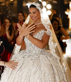 a woman in a wedding dress is clapping