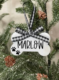 a dog bone ornament hanging from a christmas tree with the word marlow printed on it