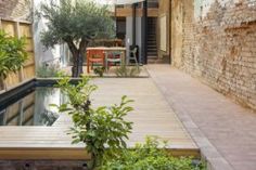 an empty courtyard with a pool and table in the center, surrounded by brick walls