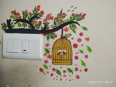 a bird in a cage painted on the wall next to a light switch