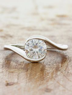 a diamond ring sitting on top of a wooden table