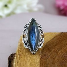 TITLE: -  Labradorite Ring, 925 Sterling Silver Jewelry, Marquise Shape Ring, Designer Split Band Ring, Vintage Style Ring, Statement Ring, Boho Ring SPECIFICATIONS: - ❖ Metal:  925 Solid sterling silver ❖ Gemstone:   Labradorite ❖ Gemstone Size: 10x28mm ❖ Total Weight:  9.3 Gram ❖ Gemstone Setting:  Bezel Note: Our use of natural stones may result in slight variations in texture and color in the actual product you receive, but the quality and grade of the stone remain consistent. FEATURES: -  * Held in a bezel setting, the elegant marquise shape labradorite dazzles in its mesmerizing hue. It is flanked by vintage style motifs adding a timeless touch. This marquise labradorite ring in 925 sterling silver is designed with a unique shank.  * About Gemstone : Labradorite displays a iridescent Gemstone Setting, Chunky Ring, Vintage Style Rings, Chunky Rings, Black Onyx Ring, Labradorite Ring, Boho Ring, Silver Accessories, Unique Gemstones