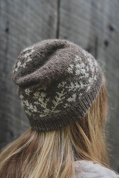 a woman with long blonde hair wearing a brown and white knitted beanie hat